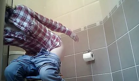 Naked babe relaxes at the lake with a fishing rod in her hands